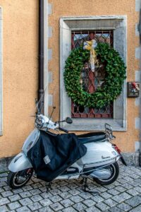 White Vespa with a large Christmas wreath at the entrance of Villa Erba in the town of Cernobbio - Lake Como, Italy - rossiwrites.com