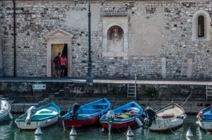Boats with the centuries-old Church of San Nicolo in the town of Lazise - Lake Garda, Italy - rossiwrites.com