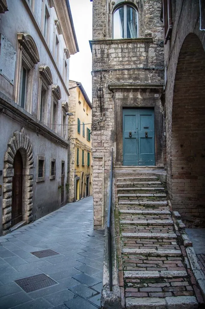 Narrow street flanked by tall houses in the historic centre - Perugia, Italy - rossiwrites.com