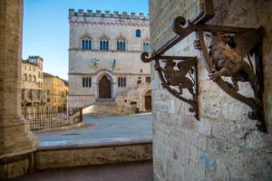 Ornamental griffins in the Loggia Braccio Fortebracci with Palazzo dei Priori - Perugia, Italy - rossiwrites.com