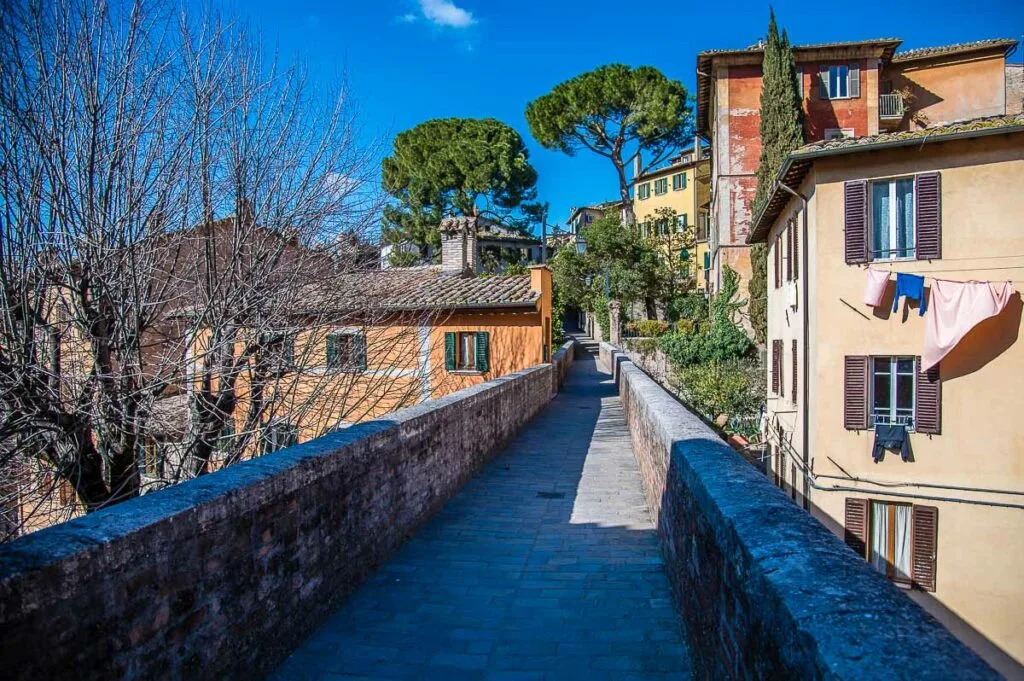 The medieval aqueduct with the adjacent houses - Perugia, Italy - rossiwrites.com