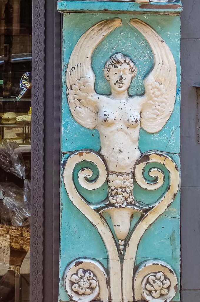 A bas-relief of the siren Partenope decorating a small bakery - Naples, Italy - rossiwrites.com