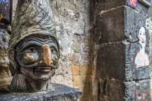 Pulcinella's bust on the corner with Via dei Tribunali - Naples, Italy - rossiwrites.com