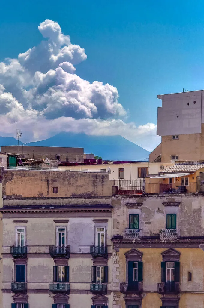 Vesuvius glimpsed behind tall residential buildings - Naples, Italy - rossiwrites.com